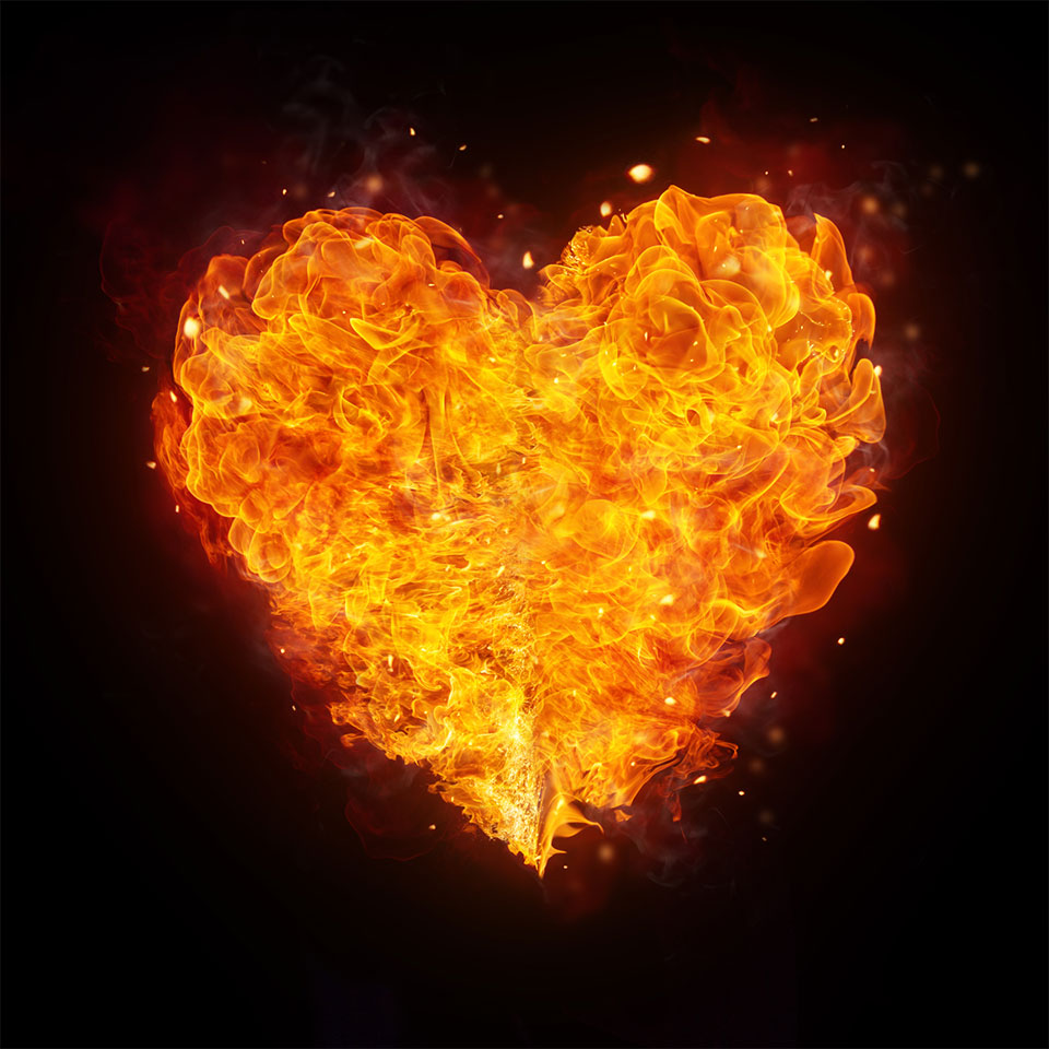 A heart shape composed entirely of yellow and orange flames, the background is dark black.